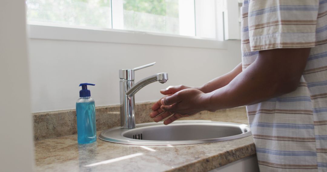 Person Washing Hands in Modern Sink with Soap Bottle Nearby - Free Images, Stock Photos and Pictures on Pikwizard.com