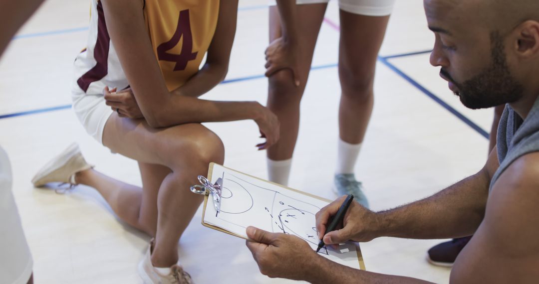 Diverse Coach Strategizing with Female Basketball Team