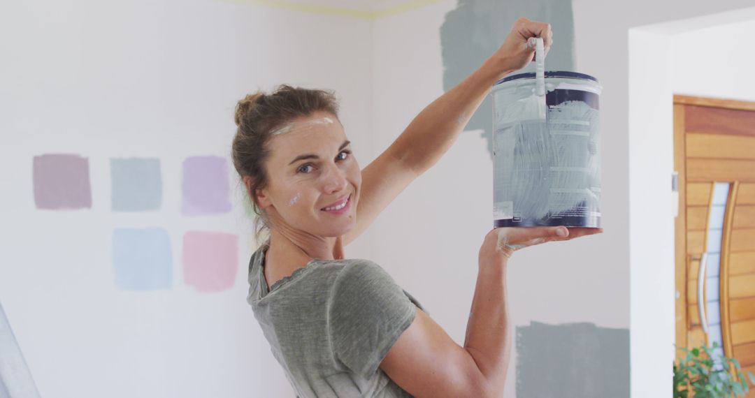 Smiling woman painting wall in modern home renovation - Free Images, Stock Photos and Pictures on Pikwizard.com