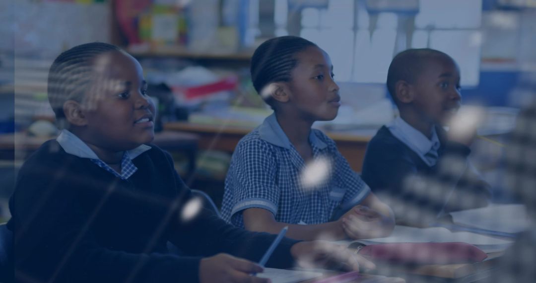 Primary school children writing and focusing in classroom with textbooks and notebooks