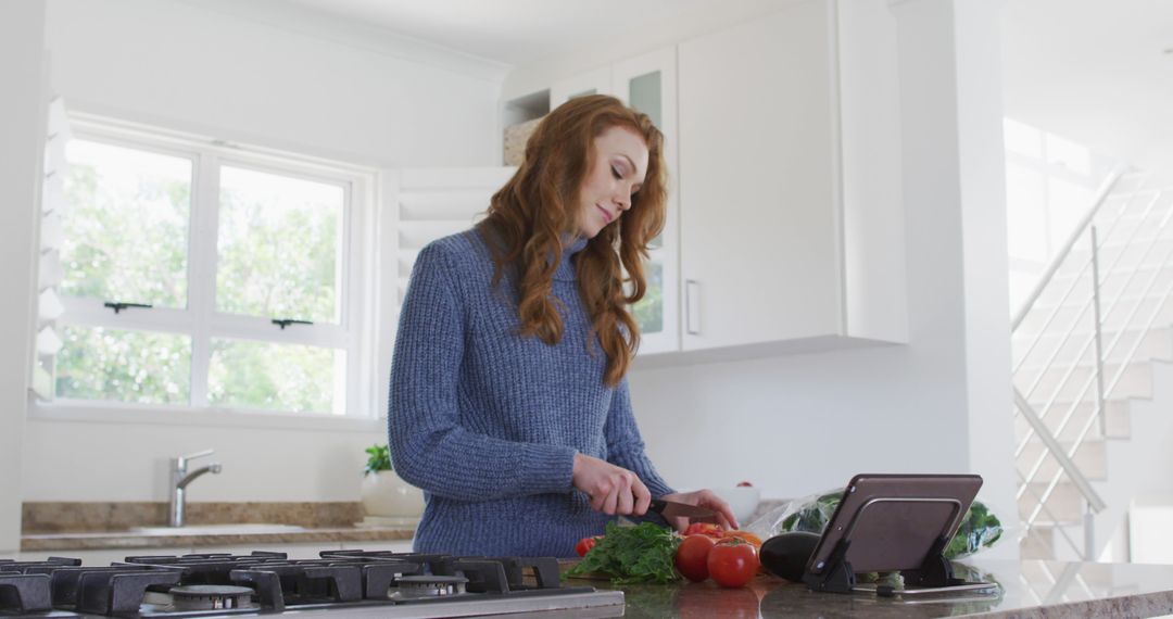 Woman Preparing Fresh Vegetables While Watching Recipe on Tablet in Modern Kitchen - Free Images, Stock Photos and Pictures on Pikwizard.com