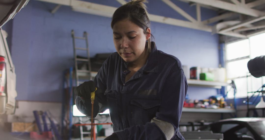 Female Mechanic Focused on Task in Car Workshop