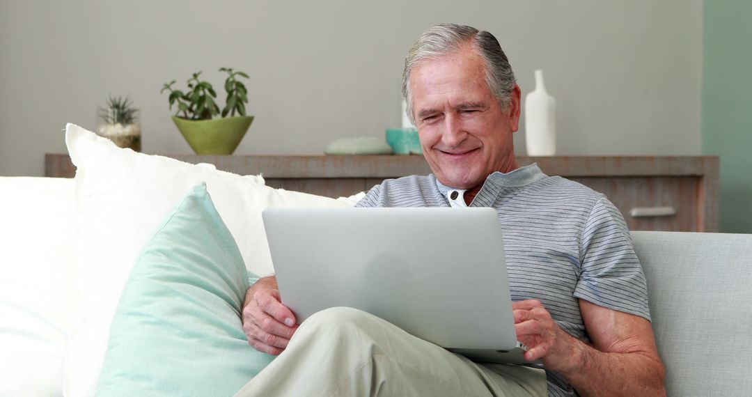 Happy Senior Man Using Tablet Sitting on Sofa at Home - Free Images, Stock Photos and Pictures on Pikwizard.com