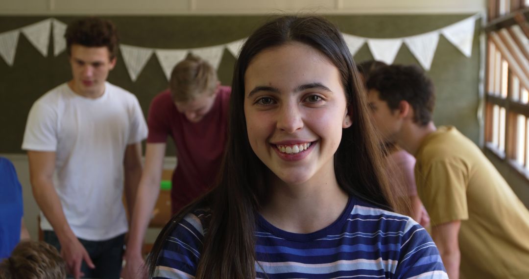 Young Woman Smiling at Camera with Group of Friends in Background - Free Images, Stock Photos and Pictures on Pikwizard.com