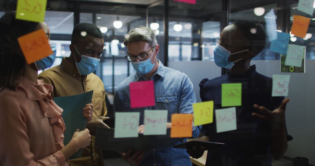 Masked Colleagues Collaborating in Modern Office on Project