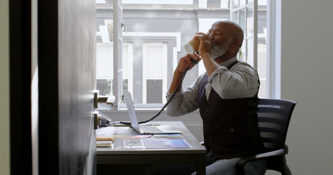 Senior Businessman Drinking Coffee and Working in Modern Office - Free Images, Stock Photos and Pictures on Pikwizard.com