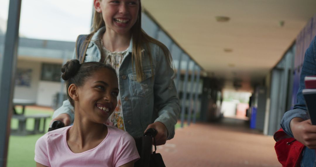 Friend Pushing Girl in Wheelchair Along School Corridor - Free Images, Stock Photos and Pictures on Pikwizard.com