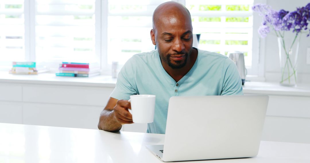 Man Drinking Coffee and Using Laptop in Modern Home Office - Free Images, Stock Photos and Pictures on Pikwizard.com