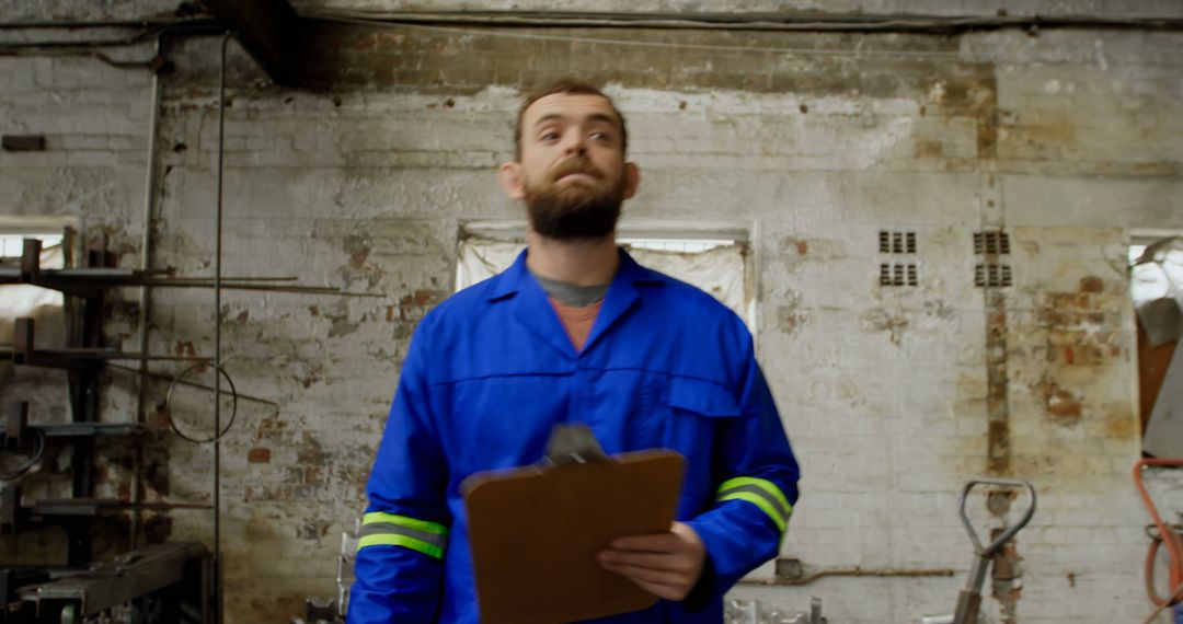 Factory Worker in Blue Coveralls Holding Clipboard - Free Images, Stock Photos and Pictures on Pikwizard.com