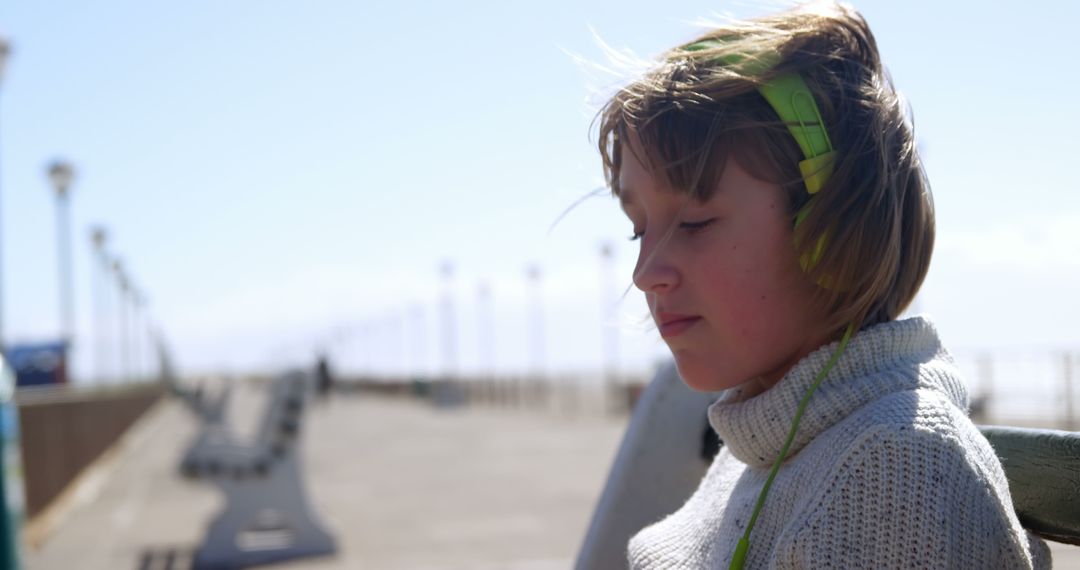 Child Enjoying Music on Pier with Headphones - Free Images, Stock Photos and Pictures on Pikwizard.com