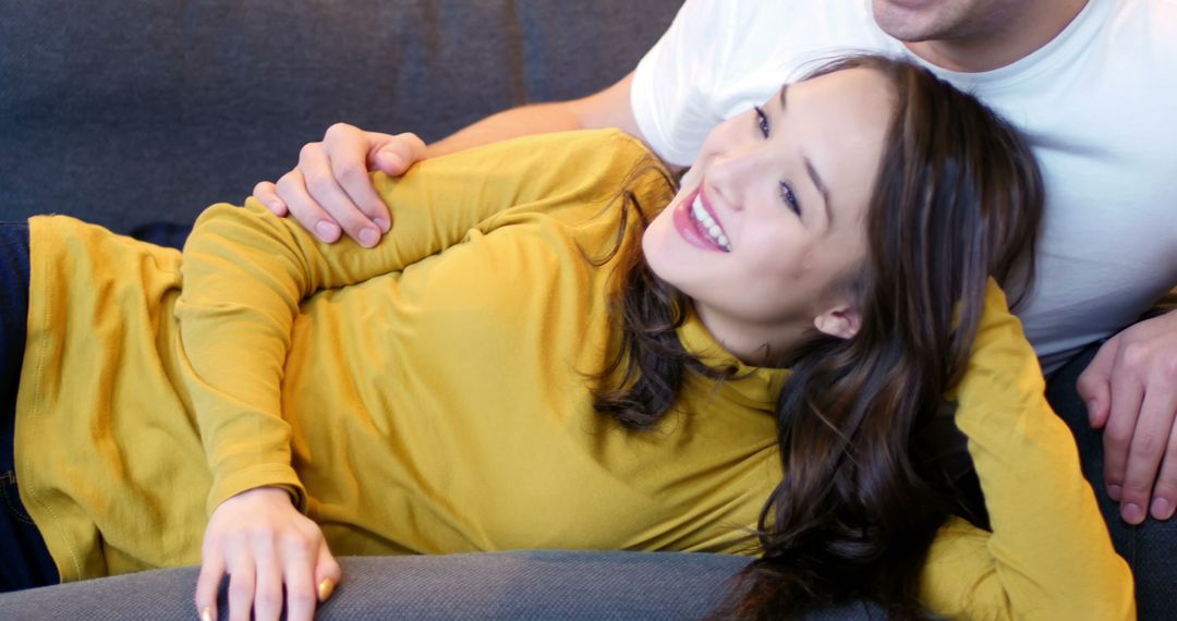 Smiling Woman Lying on Couch with Partner, Enjoying Relaxed Moment - Free Images, Stock Photos and Pictures on Pikwizard.com