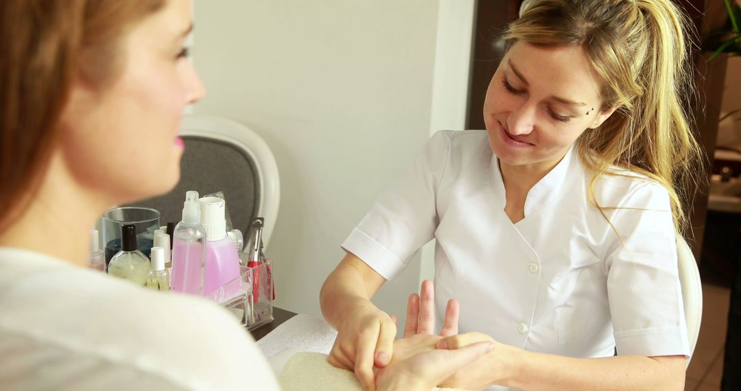 Manicurist providing hand treatment to female customer at spa - Free Images, Stock Photos and Pictures on Pikwizard.com