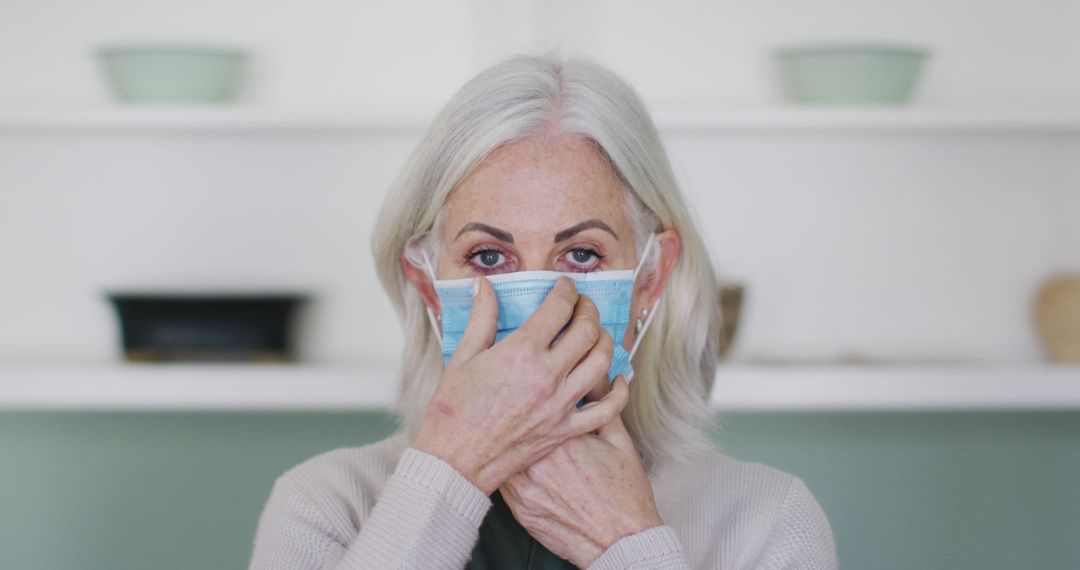 Senior Woman Putting on Face Mask at Home - Free Images, Stock Photos and Pictures on Pikwizard.com