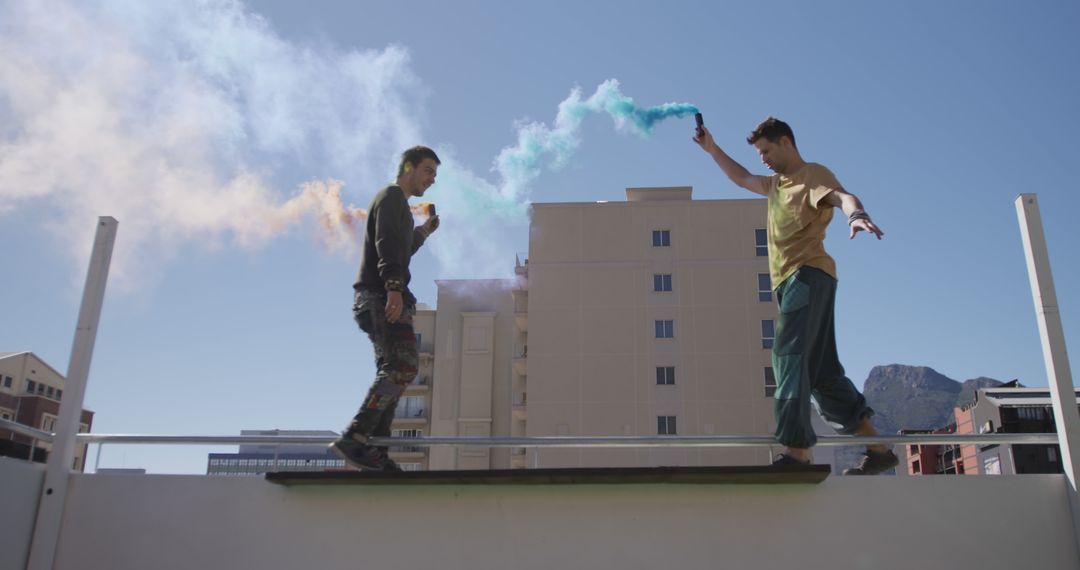 Young Men Playing with Color Smoke on Rooftop - Free Images, Stock Photos and Pictures on Pikwizard.com