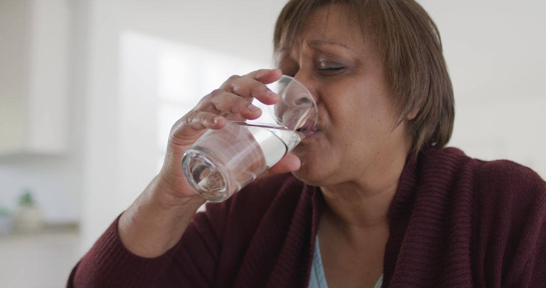 Senior Woman Drinking Water in Kitchen - Free Images, Stock Photos and Pictures on Pikwizard.com