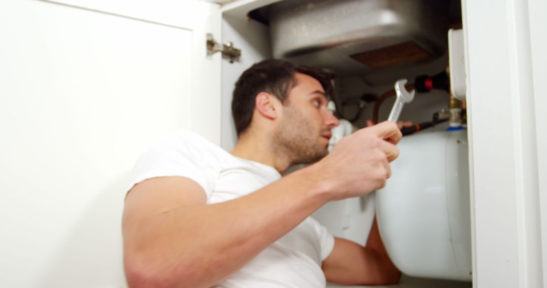 Man repairing a kitchen sink at home 4k - Free Images, Stock Photos and Pictures on Pikwizard.com