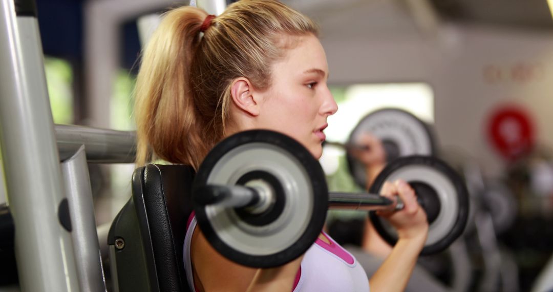 Blonde woman lifting weights in gym doing strength training - Free Images, Stock Photos and Pictures on Pikwizard.com