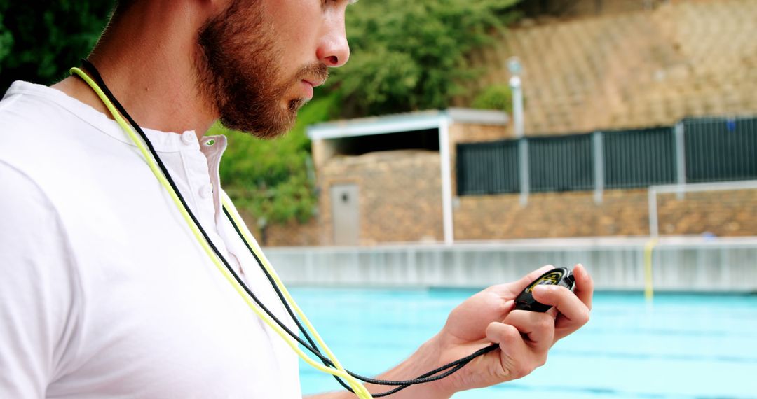 Focused Swimming Coach Timing Swimmer at Poolside - Free Images, Stock Photos and Pictures on Pikwizard.com