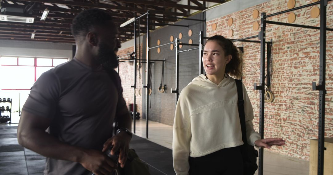 Diverse Gym Partners Discussing Fitness Routine Indoors