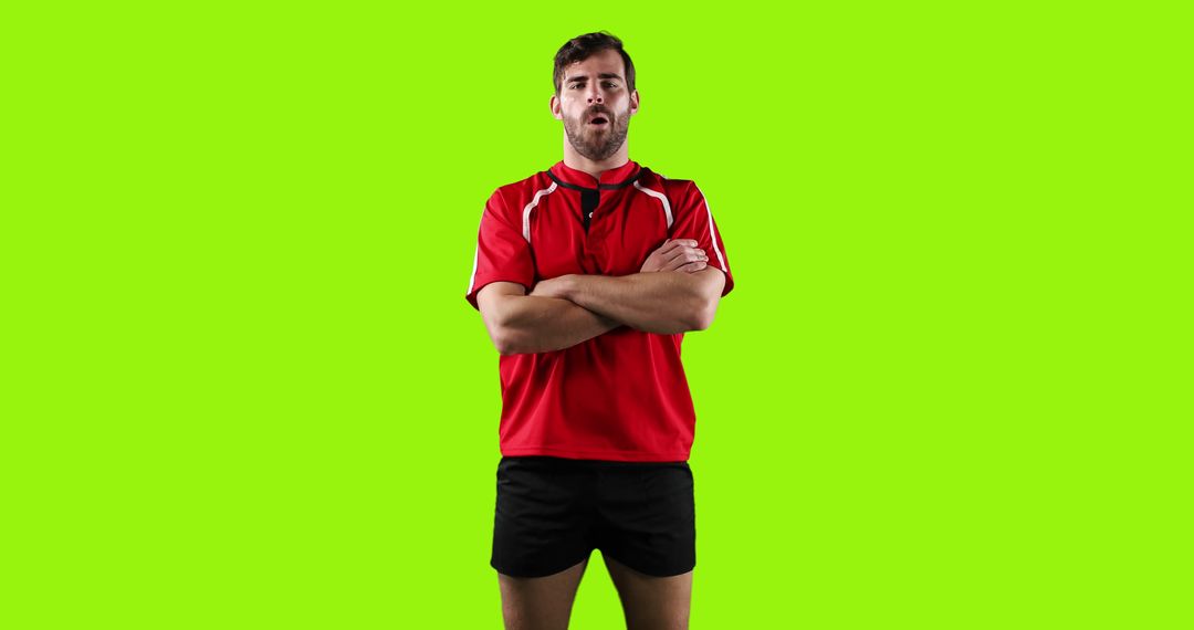 Confident Male Athlete Standing with Folded Arms on Green Background - Free Images, Stock Photos and Pictures on Pikwizard.com