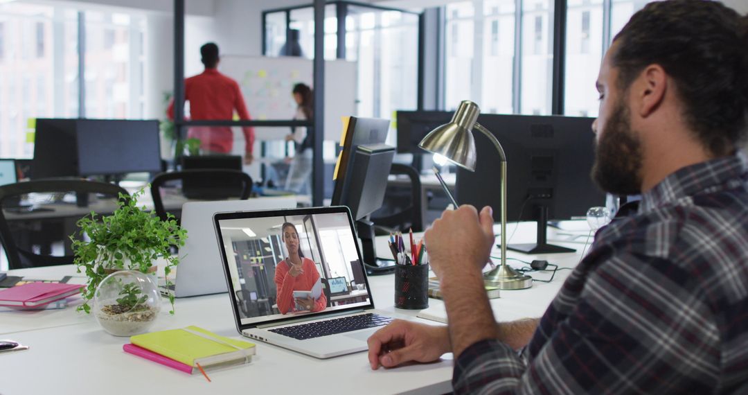 Businessman Videoconferencing with Colleague in Modern Office