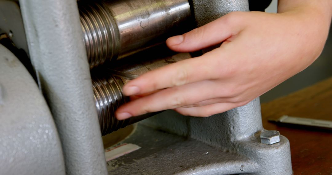 Close-up of Hands Adjusting Metal Rolling Machine - Free Images, Stock Photos and Pictures on Pikwizard.com