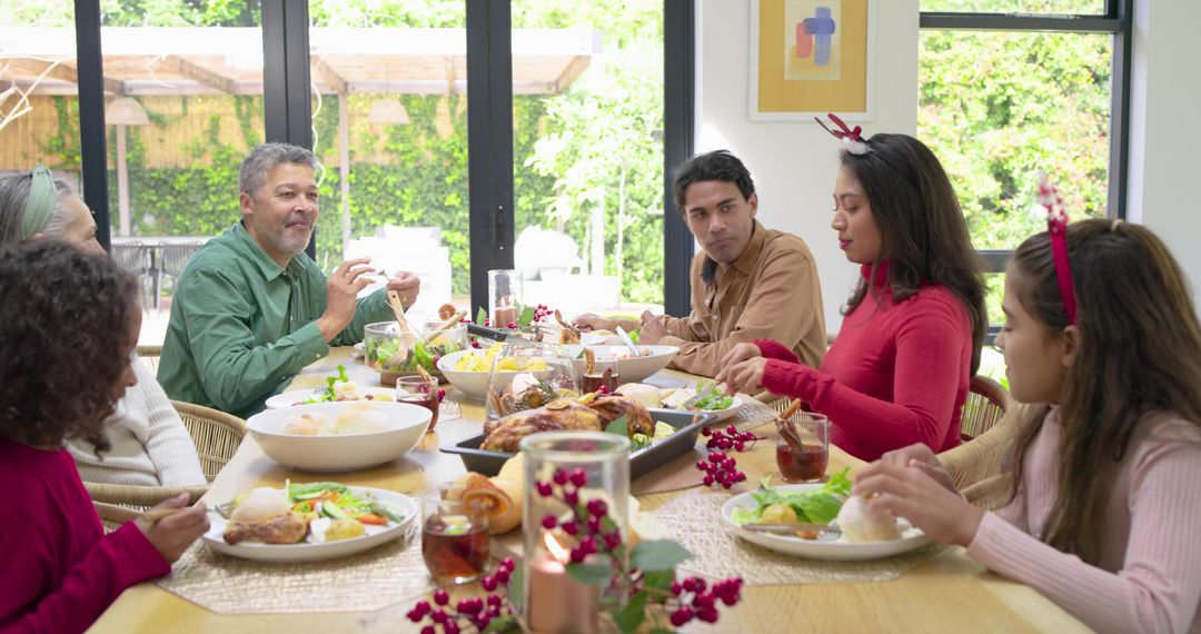 Multigenerational diverse family sharing holiday dinner around sunlit dining table