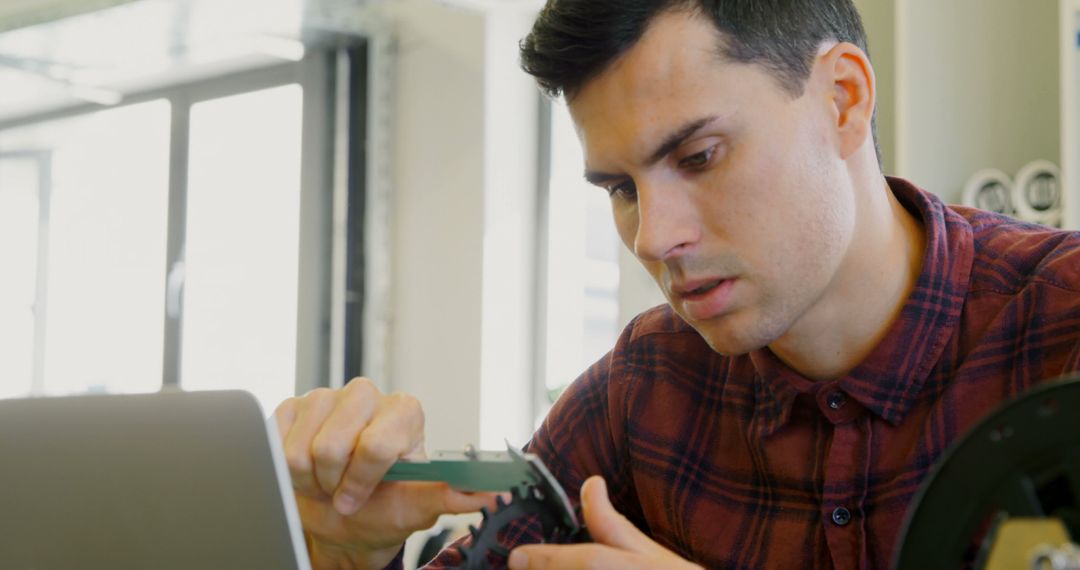 Focused Engineer Examining Electronic Components