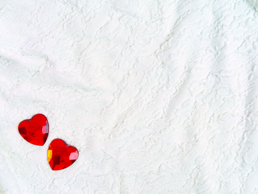 Two Red Gem Hearts on Textured White Fabric