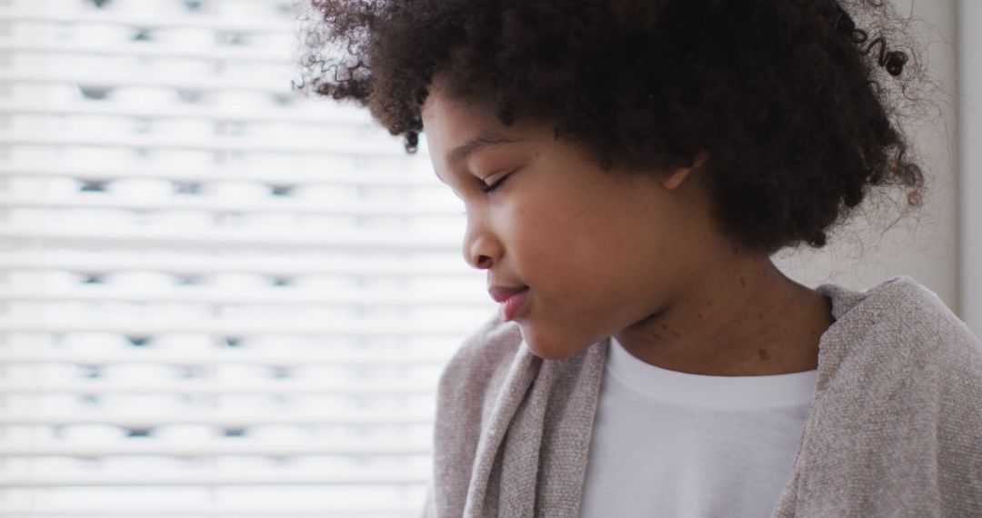 Portrait of Pensive African American Boy Sitting by Window - Free Images, Stock Photos and Pictures on Pikwizard.com