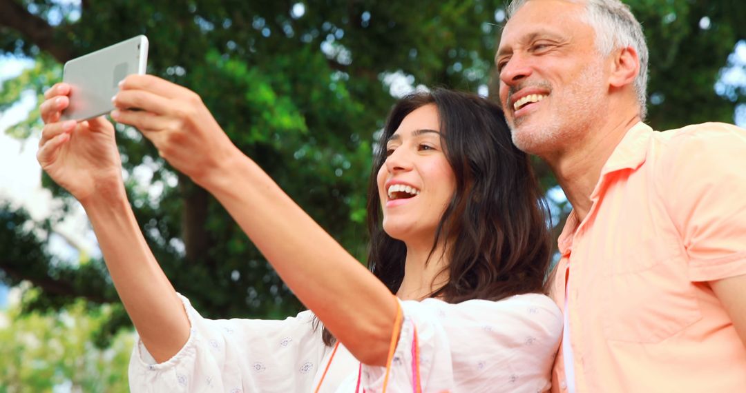 Father and Daughter Smiling While Taking a Selfie Outdoors - Free Images, Stock Photos and Pictures on Pikwizard.com