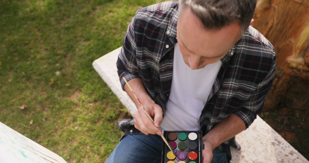 Man Painting Outdoors in Garden with Watercolors - Free Images, Stock Photos and Pictures on Pikwizard.com