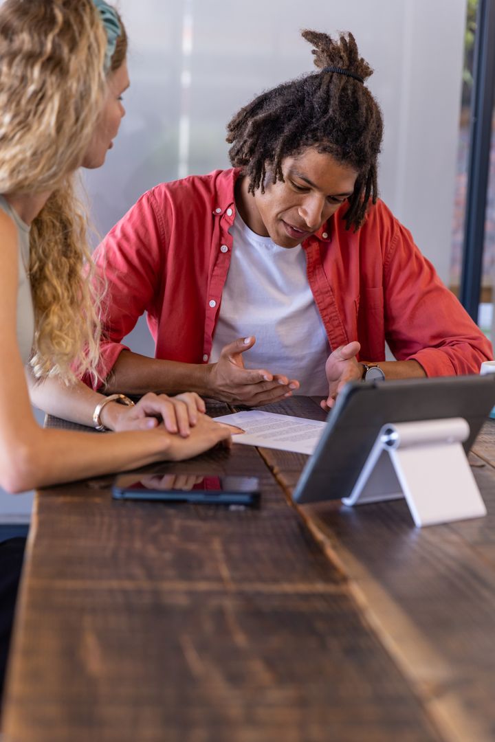 Diverse Coworkers Collaborating Over Office Document at Desk