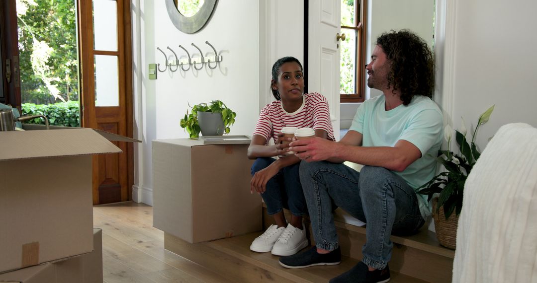 Diverse Couple Toasting with Coffee During New Home Move-In