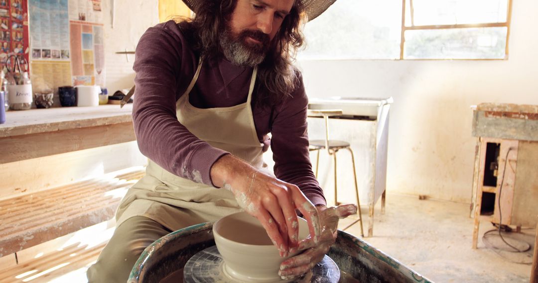 Male Potter Shaping Clay on Pottery Wheel in Studio - Free Images, Stock Photos and Pictures on Pikwizard.com