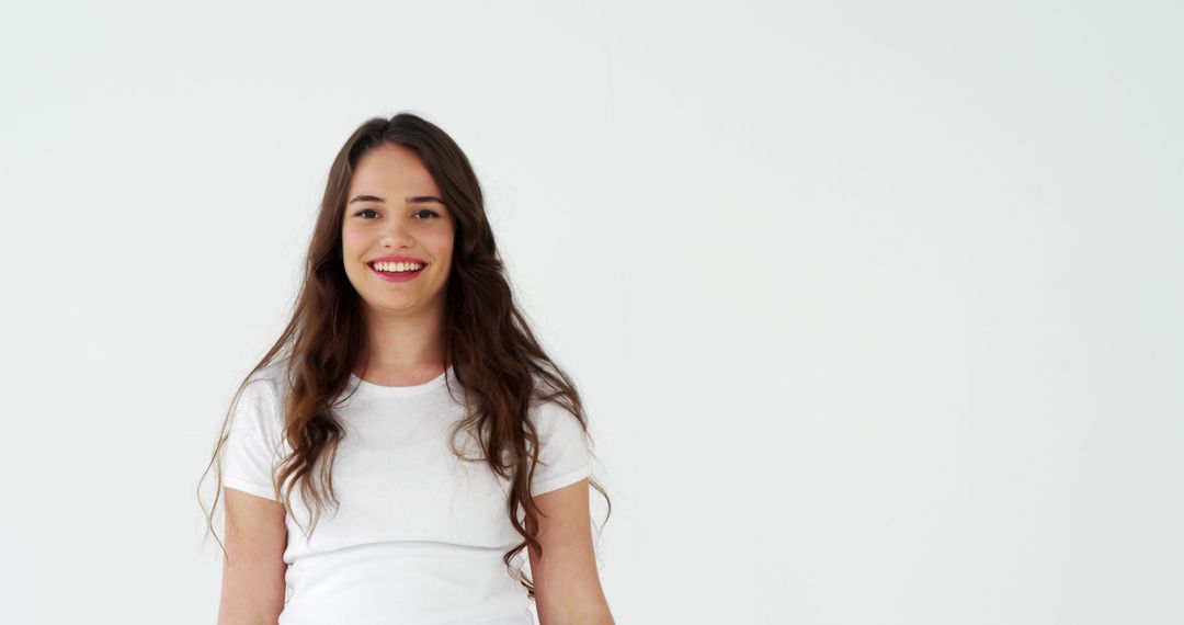 Happy Young Woman Smiling in White T-Shirt on White Background - Free Images, Stock Photos and Pictures on Pikwizard.com