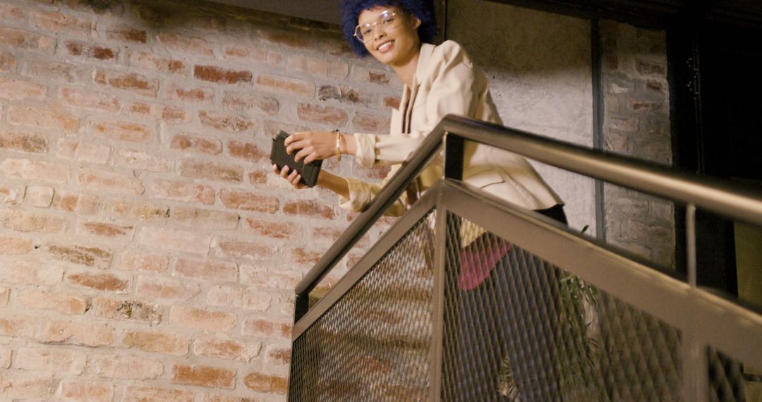 Woman with Book Standing on Modern Staircase - Free Images, Stock Photos and Pictures on Pikwizard.com