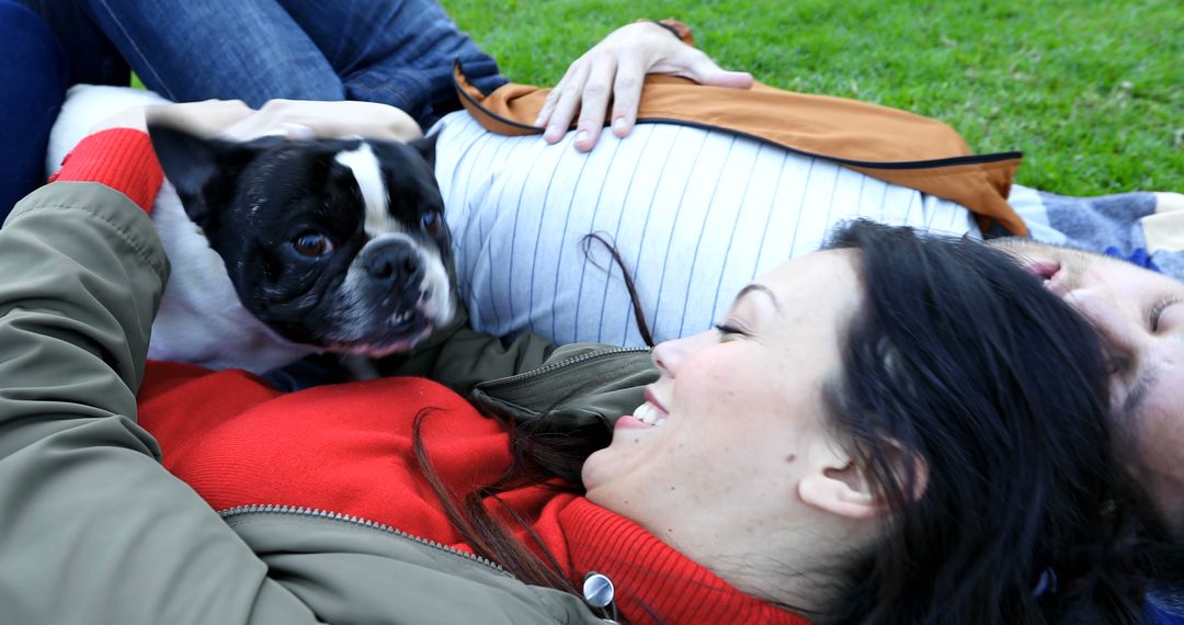 Happy Couple Relaxing with French Bulldog on Grass Outdoors - Free Images, Stock Photos and Pictures on Pikwizard.com