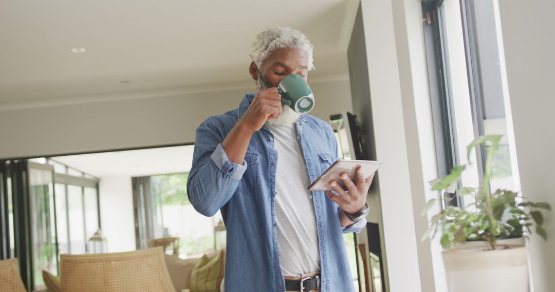 Mature Man Drinking Coffee and Using Tablet at Home - Free Images, Stock Photos and Pictures on Pikwizard.com