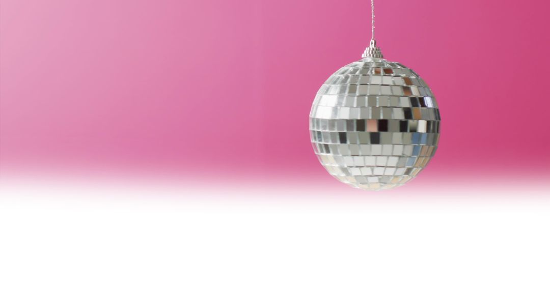 Disco Ball Reflecting on Vibrant Pink Gradient Background