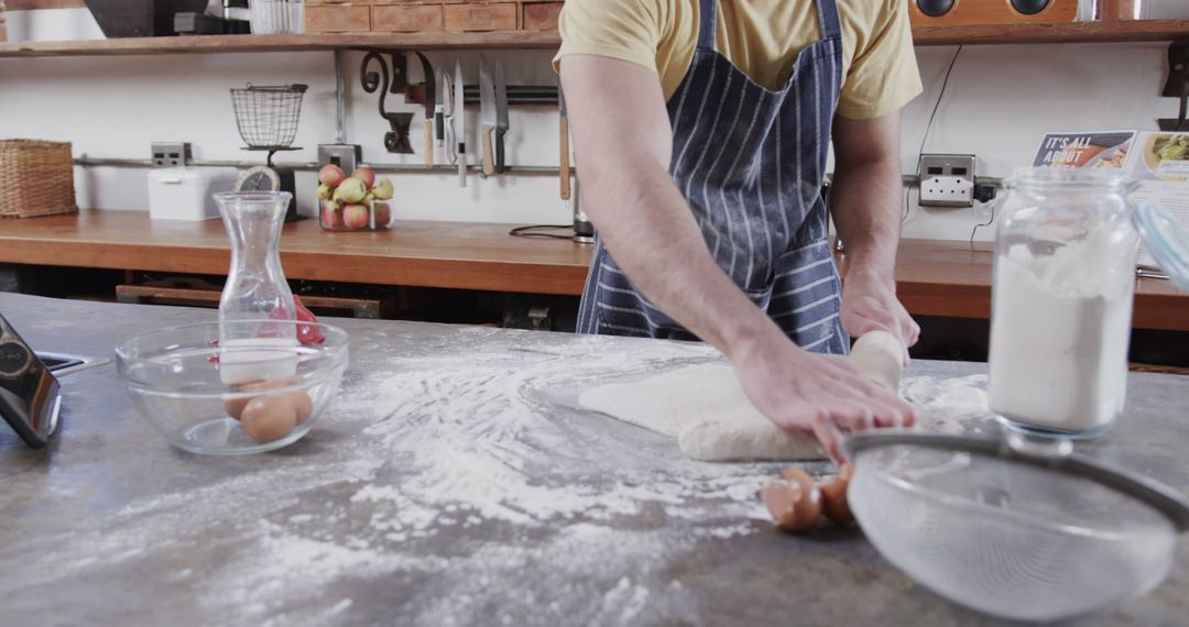 Man Baking in Kitchen Rolling Dough on Countertop