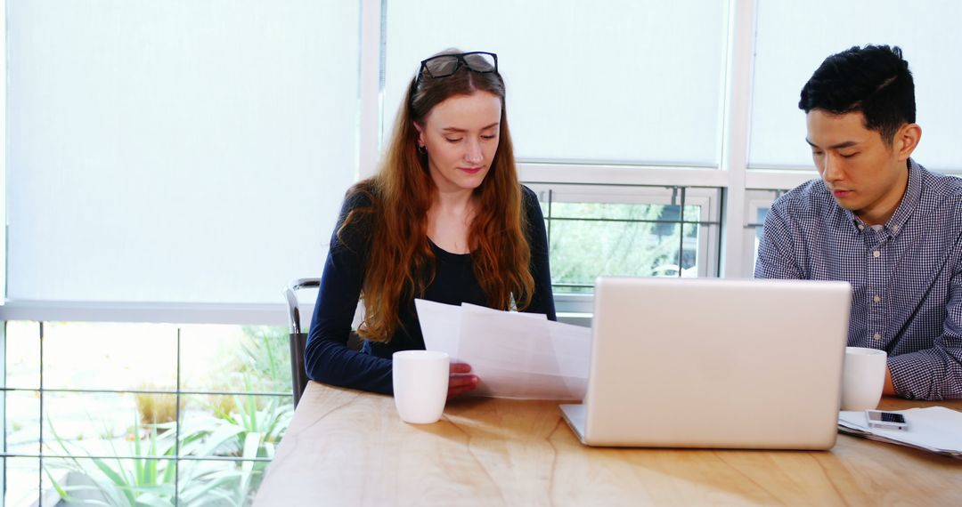Colleagues Reviewing Documents in Modern Office Setting
