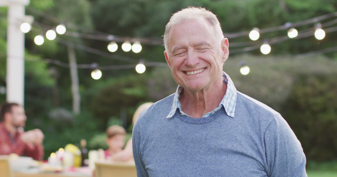 Joyful Elderly Man Enjoying Family Garden Celebration - Free Images, Stock Photos and Pictures on Pikwizard.com