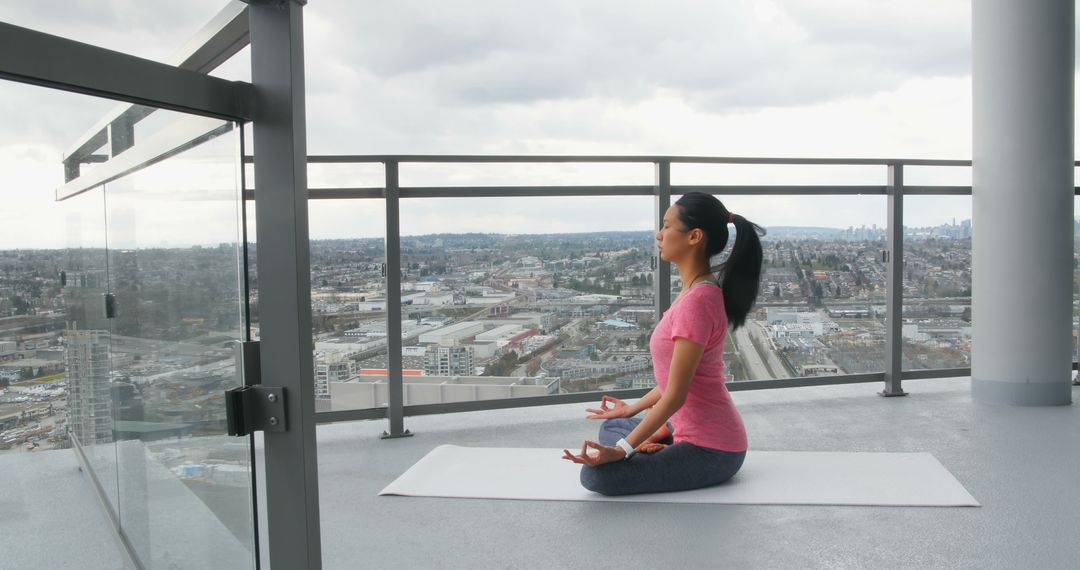 Woman Meditating on High-rise Balcony with City View - Free Images, Stock Photos and Pictures on Pikwizard.com