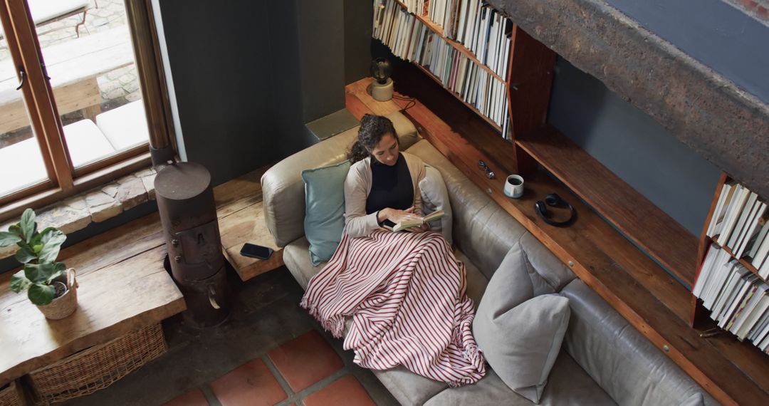 Woman Reading on Cozy Sofa in Modern Loft Apartment - Free Images, Stock Photos and Pictures on Pikwizard.com