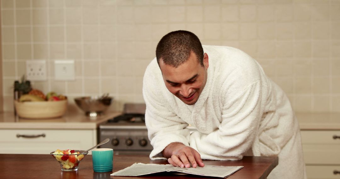 Man Relaxing in Kitchen Reading News in Bathrobe - Free Images, Stock Photos and Pictures on Pikwizard.com