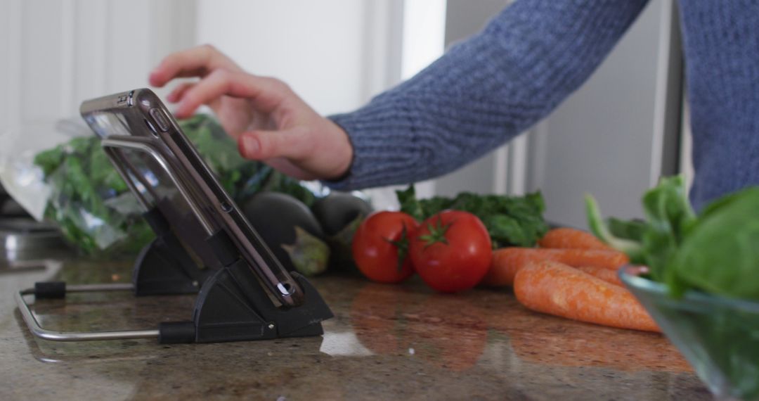 Person Using Tablet in Kitchen with Fresh Vegetables - Free Images, Stock Photos and Pictures on Pikwizard.com