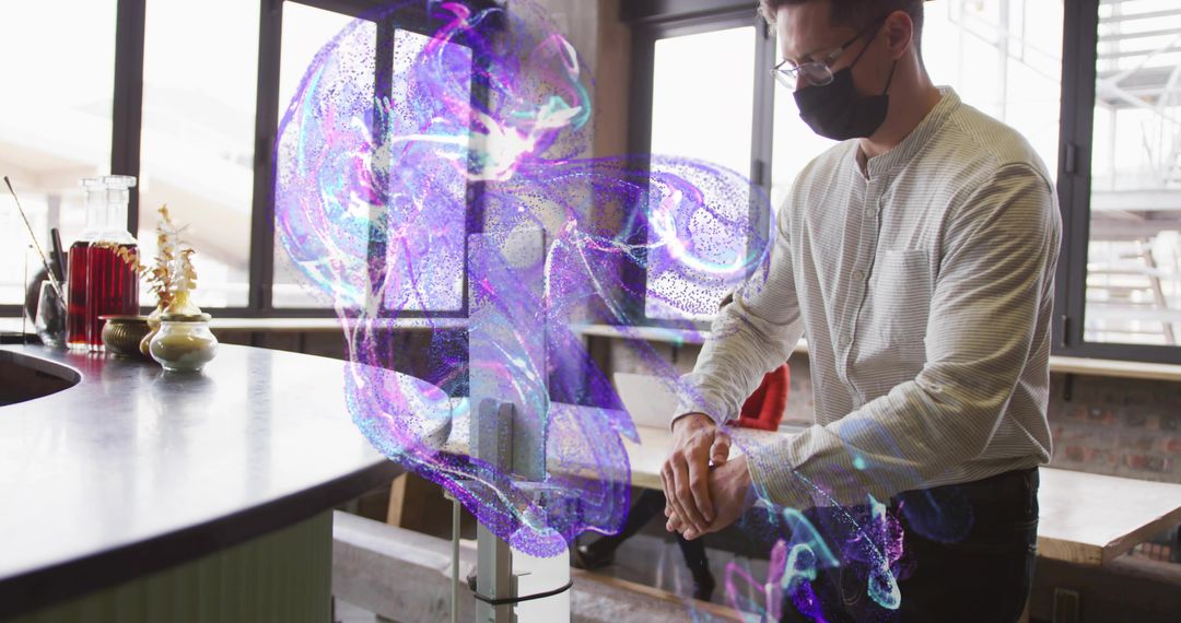Masked Man Sanitizing Hands with Automated Dispenser in Modern Cafe