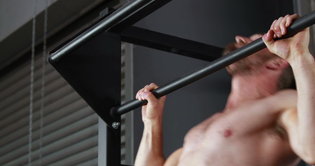 Close-up of a shirtless muscular man doing pull-ups in the gym - Free Images, Stock Photos and Pictures on Pikwizard.com