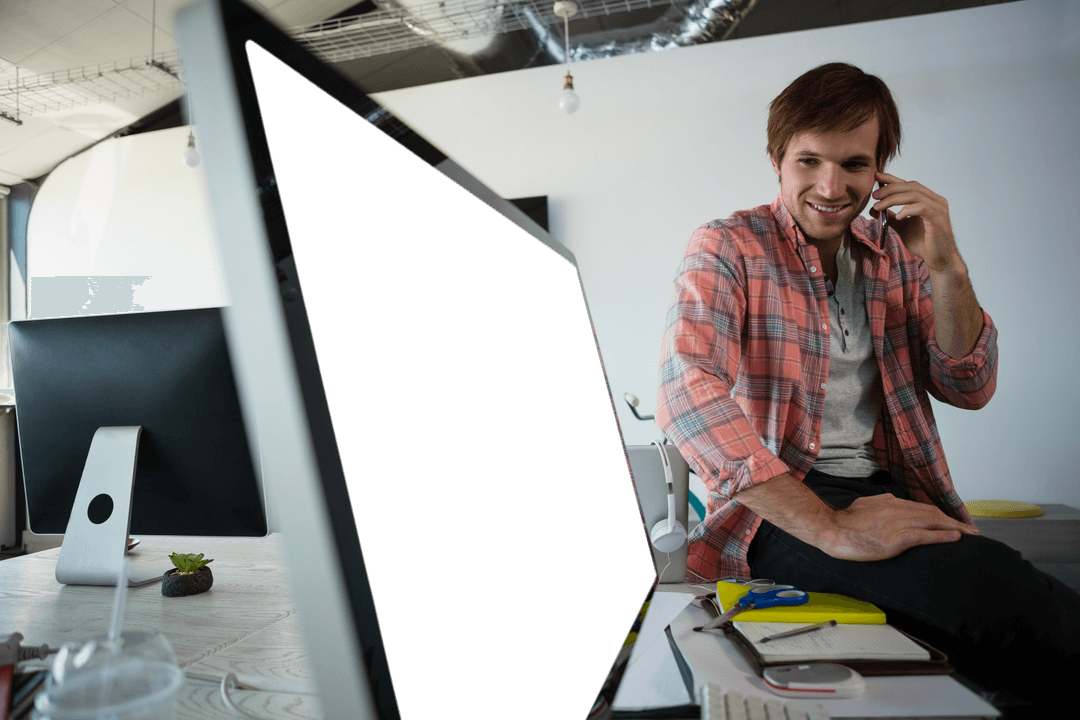 Smiling Man on Phone in Office With Transparent Monitor Screen